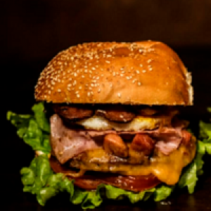 pão,  2 carnes 56g,  maionese,  2 queijo,  2 presunto,  bacon no meio e por cima ,  1 ovo,  alface,  tomate,  milho,  1 ovo de codorna,  batata frita ou palha