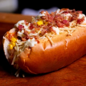 PÃO,  DUAS SALSICHAS,  MOLHO,  MILHO,  UVA PASSAS,  CENOURA,  BETERRABA,  BATATA PALHA,  BACON,  QUEIJO PARMESÃO,  OVO DE CODORNA,  ORÉGANO.