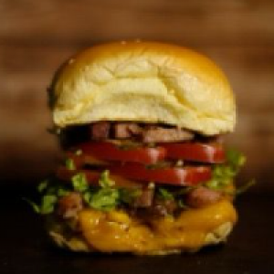 Pão,  maionese,  carne suculenta,  queijo prato,  milho,  alface,  tomate,  bacon,  batata palha ou fritas crocante e parmesão ralado.