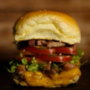Pão,  maionese,  carne artesanal 100g,  queijo prato,  milho,  alface,  tomate,  bacon,  batata palha ou fritas crocante e parmesão ralado.
