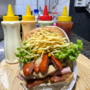 Pão,  hambúrguer caseiro,  calabresa,  frango,  salsicha,  cebola,  ovo,  bacon,  presunto,  mussarela,  tomate,  alface,  milho,  catupiry e batata palha.