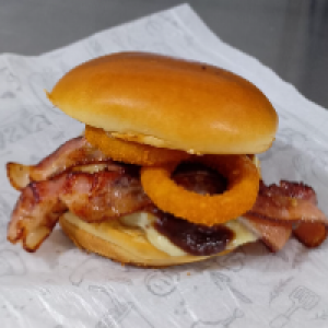 PÃO BRIOCHE,  MAIONESE ,  MOLHO BARBECUE,  CARNE ARTESANAL 180G,  QUEIJO MUSSARELA,  RODELAS DE CEBOLA ONION ,  FATIAS DE BACON DEFUMADO. ACOMPANHA FRITAS.