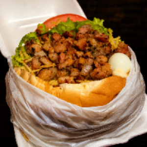 Pão,  2 carnes 56g,  2 queijos,  2 presuntos,  2 ovos,  bacon,  calabresa,  cheddar,  alface,  tomate,  batata palha,  milho,  passas e ovo de codorna. (Acompanha fritas separada)