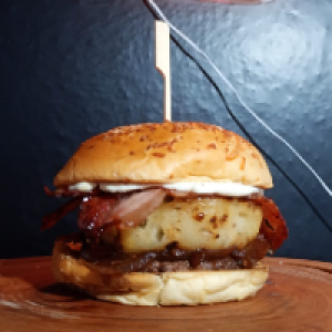 Pão gergelim,  carne bovina de 150g,  cebola caramelizada,  cream cheese,  2x bacon,  abacaxi assado e geleia de pimenta.
Foto real do lanche!