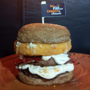 Pão australiano,  2x carne de 150g,  cebola caramelizada,  2x cream cheese,  2x bacon e mussarela empanada.
Foto real do lanche!