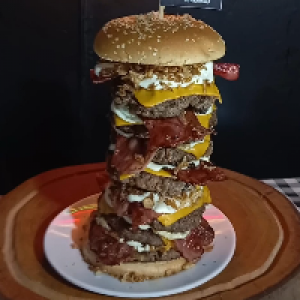 Pão gergelim,  7x carne bovina 150g,  7x cheddar fatia,  7x cheddar creme e 7x bacon,  4x cebola caramelizada + 1 batata Bobs grande.
Foto real do lanche!

