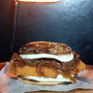 O Chicken Burger vem com,  pão de gergelim,  file de Sassami empanado,  2x Catupiry,  2x bacon fatiado e cebola caramelizada. Foto real do lanche.