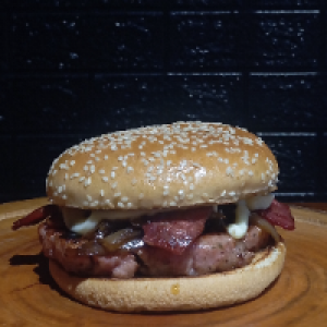 O Toscana Burger vem com,  pão de gergelim,  um hambúrguer artesanal de linguiça 150g,  2x bacon,  cebola caramelizada e Catupiry.
Foto real do produto.