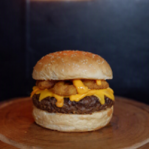 O Super Cheddar vem com,  pão de gergelim,  uma carne artesanal de 150g,  2x cheddar (fatia e creme) anéis de cebola.
Foto real do produto.